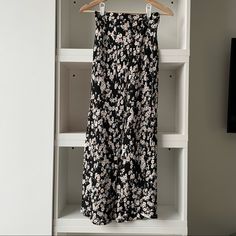 Maxi Skirt With Black Background White Floral Design. Black Midi Skirt For Brunch, Casual Black Midi Maxi Skirt, Black Midi Skirt For Day Out, Chic Wide-leg Skirt With Floral Print, Black Tiered Skirt For Brunch, Black Floral Print Skirt For Vacation, Chic Black Floral Print Maxi Skirt, Black Floral Print Tiered Maxi Skirt, Flowy Black Maxi Skirt For Day Out