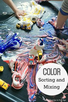 two children playing with toys in a play table filled with water and plastic wrappers