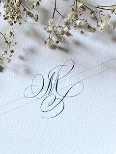 the letter k is surrounded by flowers and leaves on top of a sheet of paper