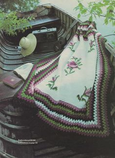 a crocheted blanket and hat sitting on top of an old car