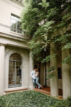 a man and woman hugging in front of a building