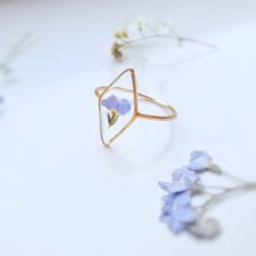 This handcrafted ring showcases real forget-me-not flowers preserved in clear resin, set in a durable brass frame. Lightweight and comfortable, it's perfect for everyday wear. A charming, nature-inspired piece, ideal for those who love floral, vintage, or boho jewellery. Available in silver or gold, it makes a thoughtful gift for special occasions like birthdays, anniversaries, or Mother's Day. This unique ring is a beautiful addition to any jewellery collection, combining natural beauty with ti Delicate Birth Flower Rings For Wedding, Delicate Promise Rings With Birth Flower, Minimalist Flower Jewelry For Promise, Nature-inspired Flower Shaped Ring As A Gift, Gold Rings With Pressed Flowers For Wedding, Minimalist Flower-shaped Promise Jewelry, Nature-inspired Rose Gold Flower Ring As Gift, Nature-inspired Flower Shaped Gift Ring, Dainty Handmade Flower Ring Gift