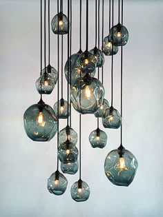 a chandelier made out of glass balls hanging from it's sides, with one light bulb turned on