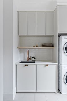 a washer and dryer in a white kitchen