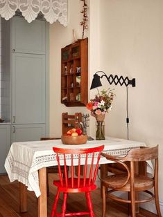 a dining room table with two chairs and a bowl of fruit on top of it