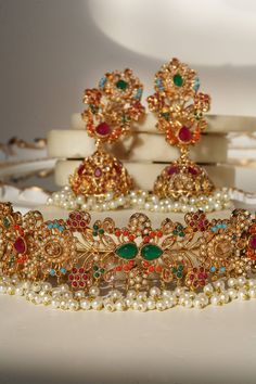 Le « Chaya - Collier ras du cou et boucles d'oreilles Jhumka » est un chef-d'œuvre royal et intemporel. Cet ensemble incarne l'équilibre délicat entre le charme des pierres multicolores et la simplicité du design moderne, créant une pièce séduisante qui fait appel à l'esthétique moderne.

 Chaque pièce de cet ensemble est conçue pour faire une impression durable. L'ensemble comprend un collier ras du cou et une paire de superbes boucles d'oreilles Jhumka superbement ornées de diverses pierres. Elegant Multicolor Jhumkas For Celebration, Elegant Multicolor Jhumkas For Festive Occasions, Elegant Multicolor Kundan Jhumkas, Multicolor Temple Jewelry Jhumkas For Celebration, Multicolor Gold Plated Fusion Jewelry, Fusion Style Jewelry For Wedding And Navratri, Multicolor Fusion Style Gold Plated Jewelry, Multicolor Fusion Gold Plated Jewelry, Multicolor Fusion Gold-plated Jewelry