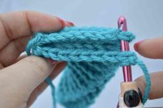 someone is crocheting the ends of a piece of yarn with a knitting needle