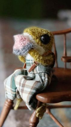 a small stuffed animal sitting on top of a wooden chair