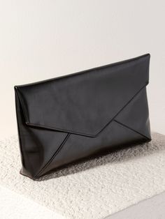 Shine bright and make a bold statement with Shiraleah’s Maddie Envelope Clutch. This chic and stylish oversized clutch is made from trendy metallic PU and adds a pop of glamorous black shimmer to any outfit. Shaped like an envelope with an elegant, triangular folding closure, this large handbag is perfect for fitting your phone, wallet, and other day or nighttime essentials. Pair with the matching Maddie Card Case, or other items from Shiraleah to complete your look! Shiraleah is a trend-driven Chic Envelope Evening Bag For Night Out, Chic Evening Clutch With Magnetic Closure, Black Envelope Evening Bag For Formal Occasions, Chic Envelope Clutch For Evening, Chic Envelope Clutch For Events, Chic Envelope Clutch For Party, Black Envelope Clutch For Formal Occasions, Trendy Envelope Evening Bag For Formal Occasions, Trendy Envelope Evening Bag For Formal Events