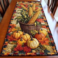 a table runner with corn on the cob and pumpkins