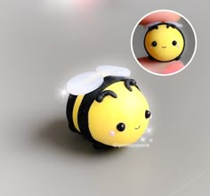 a small yellow and black toy with a bee on it's head, in front of a white background