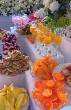 an assortment of food is displayed on the table for people to eat and have drinks