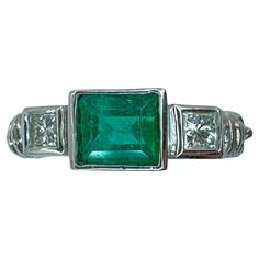 This 18k diamond and emerald ring is perfect for everyday wear.It weighs 6.88 grams and is a size 6.75. The center emerald weighs 0.70 carats and is accompanied by two side diamonds weighing a total of 0.28 carats, providing a subtle yet elegant touch to any outfit. Condition: In very good condition with some minor surface wear consistent with age. Ring size: 6.75 Markings: "750" "T864" "18k" Metal: 18k White Gold Weight: 6.88 grams Diamonds: 0.28 carats Emerald: 0.70 carats Diamond And Emerald Ring, Antique Emerald Ring, Gorgeous Jewelry, Emerald Ring, Jewelry Rings Engagement, Antique Rings, Ring Verlobung, Ring Shopping, Metallica