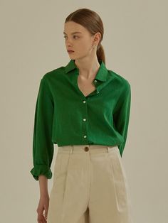 a woman in a green shirt and beige pants