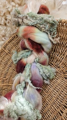 several skeins of yarn sitting on top of a wicker basket next to wool balls