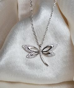 Brilla con elegancia atemporal. Nuestro collar de libélula de plata 925, adornado con brillantes diamantes de imitación Zirconias Cúbicas es el accesorio perfecto para cada ocasión. Elegant Sterling Silver Dragonfly Necklace, Elegant Sterling Silver Dragonfly Jewelry, Elegant Silver Dragonfly Jewelry, Silver Necklace With Rhinestones For Gift, Silver Dragonfly Jewelry, White Dragonfly Jewelry Gift, Elegant Dragonfly Jewelry For Wedding, Sterling Silver Dragonfly Necklace, Jewelry Care Instructions