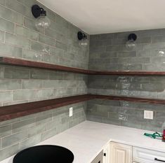 an empty kitchen with white counters and gray tile backsplashes on the walls