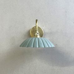 a light that is on the side of a wall with a blue shade hanging from it