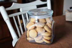 a jar filled with almonds sitting on top of a wooden table