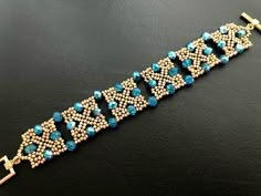 a beaded bracelet with blue beads and silver clasps on a black surface,