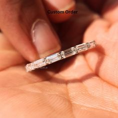 a woman's hand holding a diamond ring in her left hand with the words custom order written on it