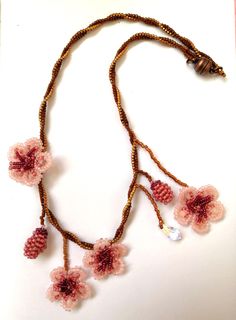 Thene of a kind asymmetrical beaded cherry blossom necklace, 100% designed and hand-crafted by me! This 40 cm unique, artisan jewelry is meant to look exactly like the magnificent spring cherry blossom branches so you can wear one on your neck and look like an ethereal nymph! It is entirely made with premium quality miyuki glass beads that they are known to made exclusively in Japan and are considered one of the most refined, luxurious tiny beads in the world! You will not wear a simple necklace. This is a piece of art made with thought, care, love, and the highest quality materials. In the personalization section, you can type the length you prefer as well as your own adjustments regarding the style of the necklace. Pink Beaded Necklace With Flower Pendant, Handmade Pink Choker As Gift, Handmade Pink Choker As A Gift, Pink Beaded Flower Pendant Jewelry, Pink Beaded Flower Pendant Necklace, Handmade Pink Flower Necklace, Handmade Delicate Beaded Necklaces With Round Beads, Handmade Delicate Beaded Necklace With Round Beads, Delicate Handmade Beaded Necklaces With Round Beads