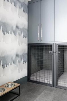 a dog kennel in front of a wall with clouds painted on it and a wooden table