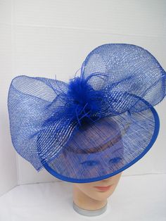 "* Bring in a little excitement to your fashion this season with this bright blue Sinamay hat designed with one gigantic netted bow. Accented with matching Ostrich feathers this is an eye catcher. * The hat is oval with a 2-1/2\" brim and with the clip on the inside can be positioned as desired. The pictures show just two positions as my model has no hair! * This particular design is off the center of the head and can be worn on either the right or left side of the head. * It is light weight, we Blue Brimmed Mini Hats For Party, Blue Brimmed Fascinator For Spring, Brimmed Blue Fascinator For Spring, Spring Party Hat With Ostrich Feathers, Blue Feather Trim Mini Hat For Kentucky Derby, Blue Mini Hat With Feather Trim For Kentucky Derby, Blue Feathered Mini Hat For Summer, Blue Feathered Fascinator For Summer, Blue Feathered Costume Hats And Headpieces For Spring