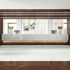 an empty lobby with marble flooring and white walls, along with two lamps on either side of the reception counter