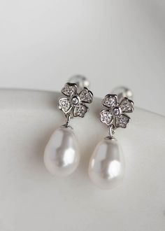 A Juliette pearl drop earrings are a charming set for the modern romantic. These short drops feel fresh and elegant with everlasting floral motifs and timeless Swarovski pearl drops. Available in silver or gold tones. Please leave your colour preference in the message box at checkout. * DETAILS * > Designed in Australia. Worldwide shipping > Silver or gold plated findings, cubic zirconias, Swarovski pearls > Dimensions: 22mm > Colour: Silver or gold * MADE TO ORDER * The Juliette ear Classic Drop Flower Earrings For Formal Occasions, Formal Pearl White Flower Drop Earrings, Formal Pearl White Flower Earrings With Pearl Drop, Elegant Silver Pearl Flower Earrings, Classic Flower-shaped Pearl Earrings For Formal Occasions, Elegant Pearl White Flower Earrings For Formal Occasions, Elegant Pearl White Flower Earrings For Formal Events, Elegant Formal Pearl White Flower Earrings, Classic Pearl Drop Flower Earrings Gift