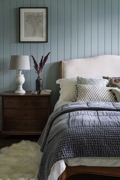 a bedroom with blue walls and white bedding