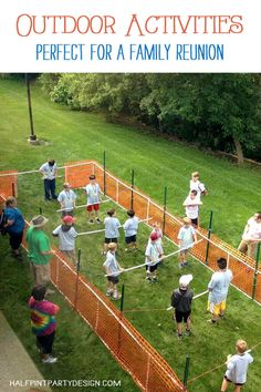 an outdoor activity area with children playing in the grass and on the ground, surrounded by orange fences