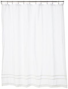 a white shower curtain hanging on a metal rod