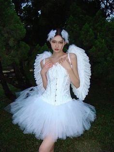 a woman dressed in an angel costume posing for the camera with her hands on her chest