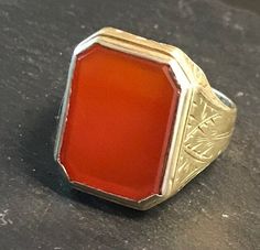 "Classic 14k yellow gold ring, rectangular bezel set Carnelian (16 by 13mm), with terrific hand engraved setting, strong good looking design.  Size 7 3/4, wt.-  4.3 grams.  Top of ring approx. 3/4\" north to south on finger.  Classic shape and easy to wear.  Circa 1920-30.  good condition, clean design, any wear commensurate with age and slight, Photos show details." Rectangular 14k Stamped Signet Ring Collectible, Red Rectangular Ring With Polished Finish, Gold Rectangular Cabochon Rings, Rectangular Yellow Gold Signet Ring With Gemstone, Rectangular Gold Cabochon Rings, Rectangular Cabochon Gold Rings, Red Rectangular Rings With Polished Finish, Rectangular Red Rings With Polished Finish, Formal Rectangular Cabochon Ring