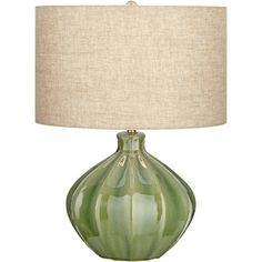 a green lamp with a beige shade on it