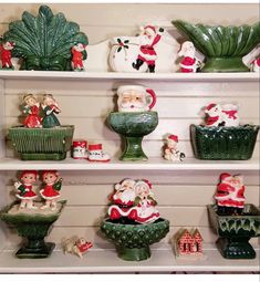 christmas figurines on shelves with santa clause and other holiday decorations in green pots