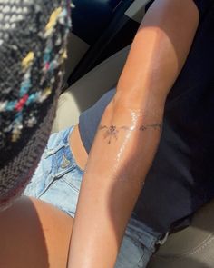 a person with a tattoo on their arm sitting in a car