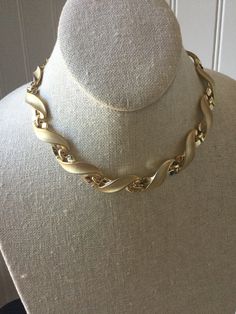 This gorgeous vintage statement choker has satin gold and shiny links, signed TRIFARI.  IT shimmers as the light bounces between the two contrasting finishes, giving this designer piece a fabulous look.  Choker necklaces are always in style and fashionable!  This piece is in very good vintage condition. TRIFARI was a top costume jewelry manufacturer in America in past decades,  producing highly crafted quality pieces that were always fashion forward.  Their jewelry is much valued by collectors today. Thanks for shopping alliesjewelbox.Etsy.com Jan Jewelry Manufacturer, Vintage Trifari, Statement Choker, Jewelry Manufacturers, Choker Necklaces, In America, Vintage Gold, Costume Jewelry, Favorite Jewelry