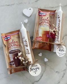 two packages of coffee drink sitting on top of a table next to candles and hearts