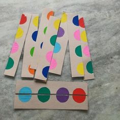 four pieces of craft paper with colored dots on them