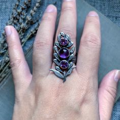 Amethyst silver ring, amethyst jewelry, lavender jewelry, handmade ring, artisan jewelry, crystal ring, purple gemstone ring, witchy jewelry Three amethyst gemstones lay in the middle of a lavender sprig. Each petal has been sawed by hand and attached to the stone bezels. I've also textured the petals and given the piece a soft satin finish. I've also oxidized the flower for contrast. The band of the ring is textured and wide, ensuring a comfortable fit. All components of the ring are hand fabri Mystical Sterling Silver Amethyst Ring, Silver Amethyst Ring In Mystical Style, Mystical Round Amethyst Ring, Purple Mystical Jewelry Ring, Mystical Amethyst Ring In Sterling Silver, Mystical Sterling Silver Purple Rings, Mystical Sterling Silver Rings In Purple, Mystical Amethyst Gemstone Rings, Mystical Purple Sterling Silver Rings