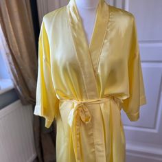 This beautiful sun yellow silk bathrobe/ dressing gown is perfect for you and your bridesmaids/ bridesmen to wear whilst getting ready for your special day. Or it can be given as a special gift for a Birthday, Mother's Day or any other special occasion.  It is made in three sizes,  UK 8-16, UK 20-24 and UK 26-30. The plus size gowns can take 2-3 weeks for delivery.     It can also be made in smaller children's sizes to fit your flower girls too -please message us for details. It can be personalized with vinyl text in Gold, Silver, Rose Gold, White, Black or Pink on both the back and front.  All items are tailor made and shipped from the UK. Available in over 30 colours. Please use the following link if you would like up to 3 fabric samples: https://www.etsy.com/uk/listing/994454470/silk-an Yellow Pajamas, Silk Bathrobe, Floral Gown Dress, Satin Dressing Gown, Gown Elegant, Silk Dressing Gown, Plus Size Gowns, Satin Sleepwear, Sun Yellow