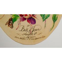 the back side of a wooden plaque with flowers and butterflies painted on it's sides