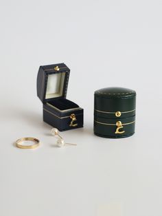 an open ring box next to a pair of earrings