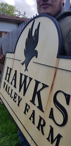 a man holding a sign that says hawk valley farm