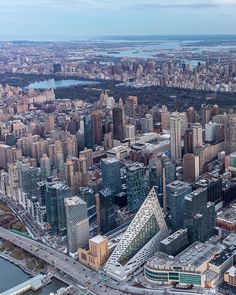 an aerial view of a large city with tall buildings and lots of water in the background