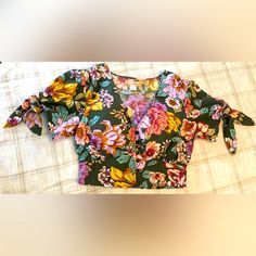 B.O.G Collective V-Neck Crop Blouse | New | Short Sleeves With Side Tie Design | Buttoned Down | Elastic Waist (Back Only) | Romantic Floral Pattern | 100% Polyester | Pet And Smoke Free Home | Trendy V-neck Floral Print Blouse, Multicolor Floral Print V-neck Top, Chic Floral Print V-neck Crop Top, Chic Floral Print V-neck Top, Green Printed V-neck Top, Casual Floral Print V-neck Top For Summer, Green V-neck Top For Day Out, Printed V-neck Crop Top For Summer, Multicolor V-neck Top For Spring