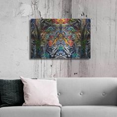 an abstract painting on the wall above a couch in a room with white walls and pillows