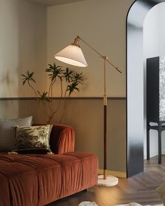 a living room with an orange couch and floor lamp